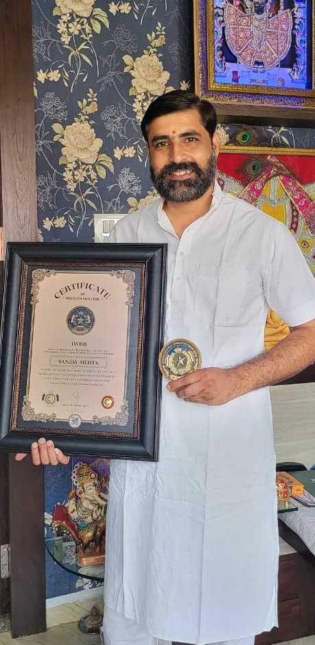 Sanjay Mehta holding framed IWRB certificate and medal